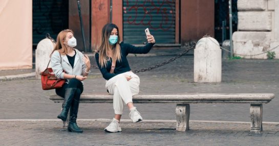 Women in masks talking on bench - test & treat